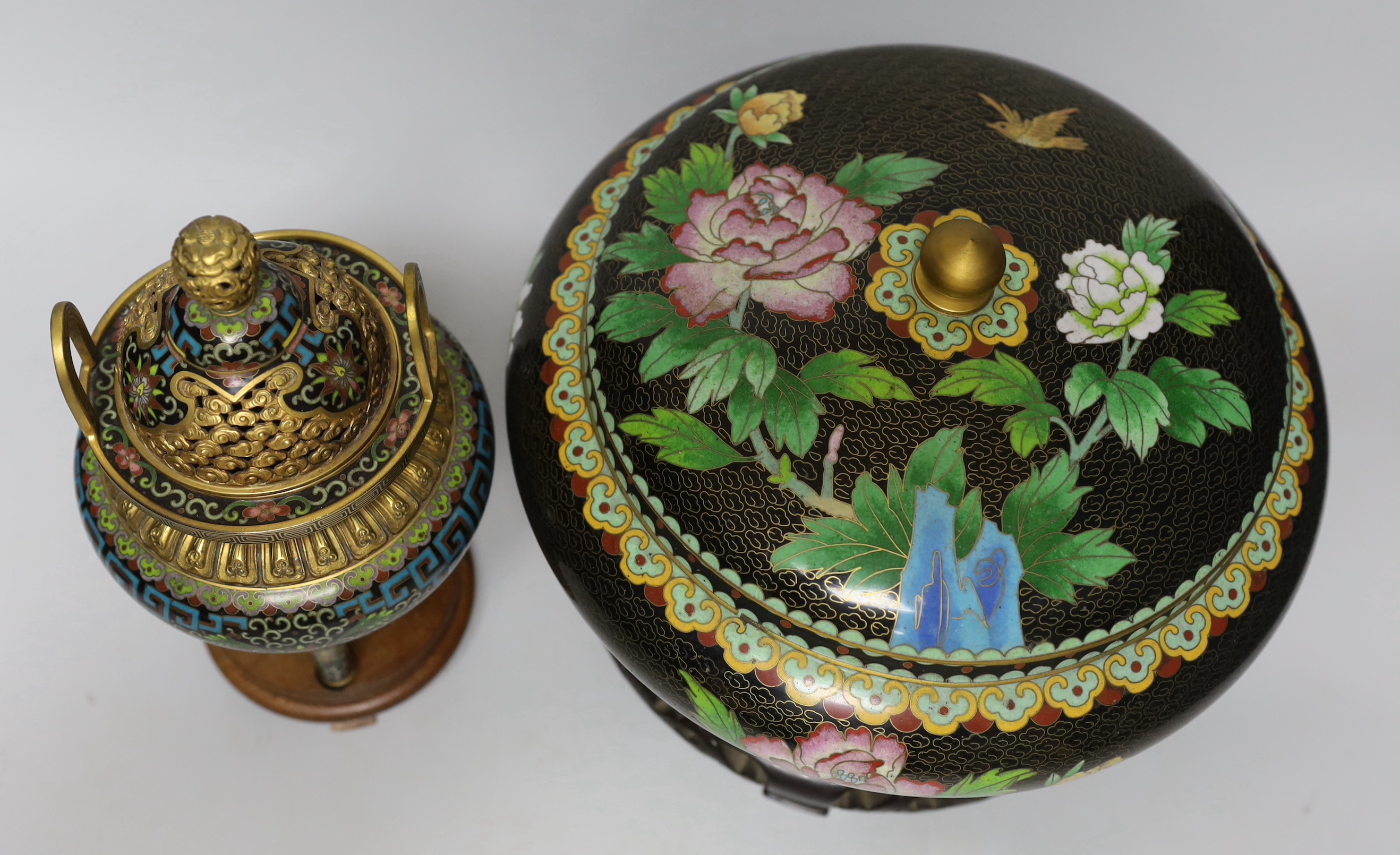 A Chinese cloisonné enamel three footed vase and cover together with a censer and cover, each raised on hardwood stands, the largest 26cm in diameter